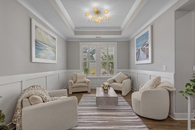 945 Waterbridge Blvd, Myrtle Beach, SC 29579 - living room with a chandelier, wood finished floors, a tray ceiling, crown molding, and a decorative wall
