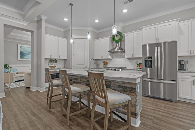 945 Waterbridge Blvd, Myrtle Beach, SC 29579 - kitchen featuring stainless steel fridge with ice dispenser, crown molding, a breakfast bar, a center island with sink, and backsplash