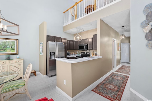 2150 Longwood Lakes Dr Unit 2150, Myrtle Beach, SC 29579 - kitchen featuring stainless steel appliances, dark brown cabinets, light wood-type flooring, a high ceiling, and pendant lighting