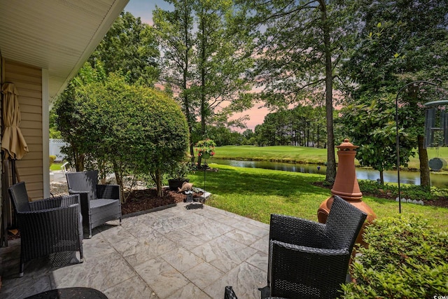 2150 Longwood Lakes Dr Unit 2150, Myrtle Beach, SC 29579 - patio terrace at dusk featuring a patio, a water view, and a lawn
