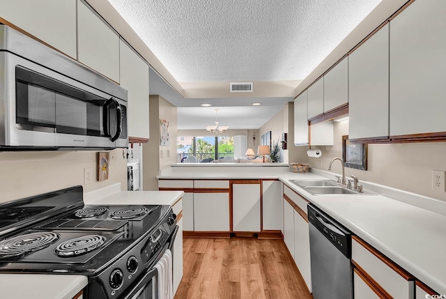 741 Retreat Beach Cir Unit B-1-A, Pawleys Island, SC 29585 - kitchen featuring stainless steel appliances, a textured ceiling, light countertops, and a chandelier