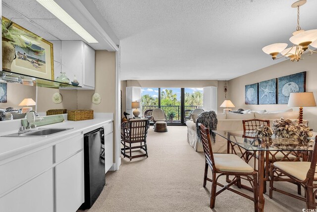 741 Retreat Beach Cir Unit B-1-A, Pawleys Island, SC 29585 - kitchen featuring a chandelier, light carpet, light countertops, white cabinetry, and open floor plan