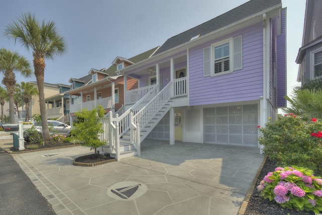 4525 Landing Rd, Little River, SC 29566 - coastal inspired home with stairs, covered porch, driveway, and a garage