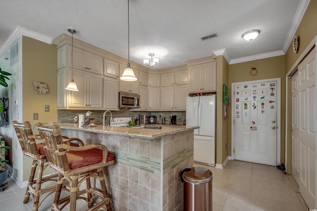 901 W Port Dr Unit 305, North Myrtle Beach, SC 29582 - kitchen featuring white appliances, a peninsula, tasteful backsplash, ornamental molding, and light stone counters