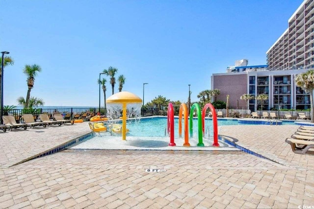 201 74th Ave N Unit 707, Myrtle Beach, SC 29572 - view of playground featuring a water play area, a community pool, and a patio area
