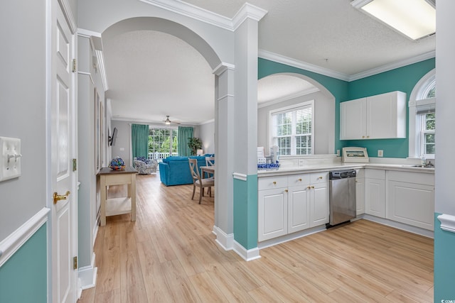 5825 Catalina Dr Unit 125, North Myrtle Beach, SC 29582 - kitchen featuring stainless steel dishwasher, arched walkways, white cabinets, ornamental molding, and a textured ceiling