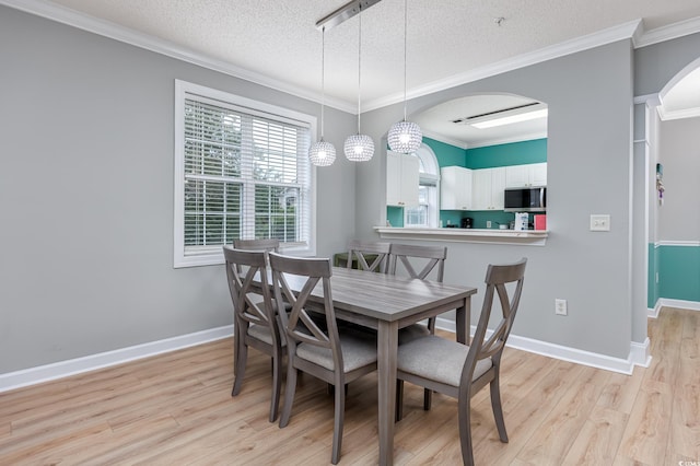 5825 Catalina Dr Unit 125, North Myrtle Beach, SC 29582 - dining space with light wood finished floors, arched walkways, a textured ceiling, and ornamental molding