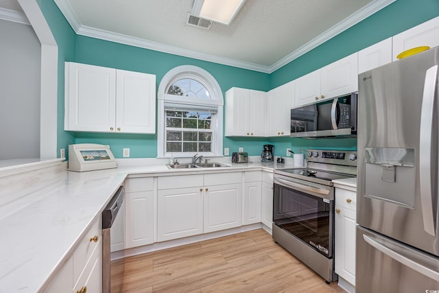 5825 Catalina Dr Unit 125, North Myrtle Beach, SC 29582 - kitchen with appliances with stainless steel finishes, crown molding, white cabinetry, light countertops, and a textured ceiling