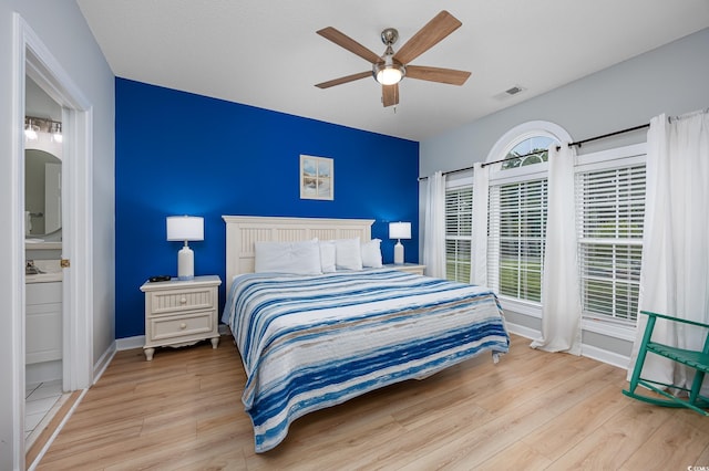 5825 Catalina Dr Unit 125, North Myrtle Beach, SC 29582 - bedroom featuring light wood-style floors, ensuite bath, and ceiling fan