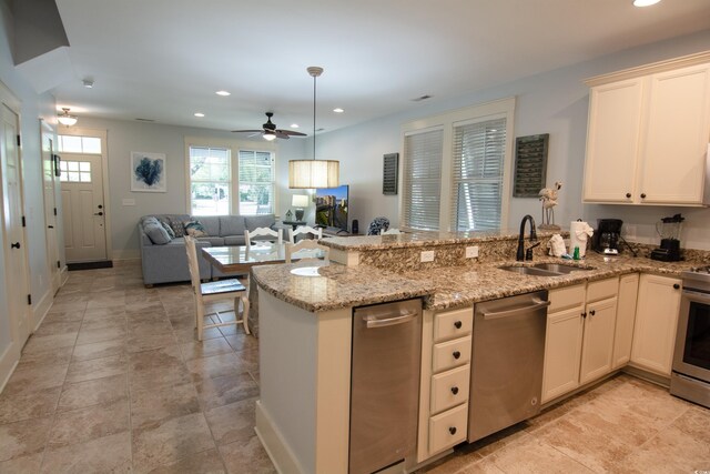 4901 N Market St, North Myrtle Beach, SC 29582 - kitchen featuring appliances with stainless steel finishes, a peninsula, open floor plan, recessed lighting, and light stone countertops