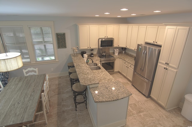 4901 N Market St, North Myrtle Beach, SC 29582 - kitchen featuring stainless steel appliances, a peninsula, light stone counters, a breakfast bar area, and recessed lighting