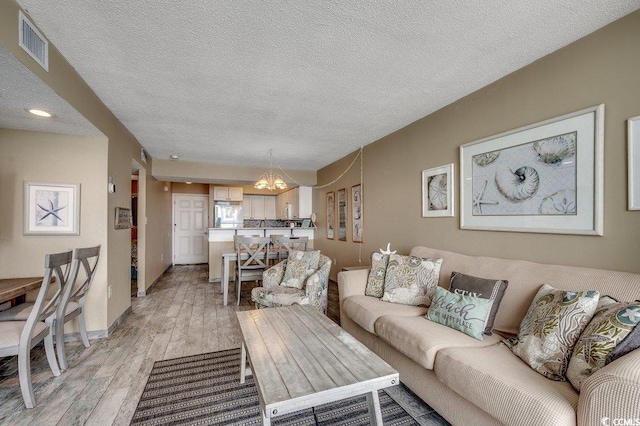 9400 Shore Dr Unit 617, Myrtle Beach, SC 29572 - living area with a chandelier, light wood finished floors, and a textured ceiling