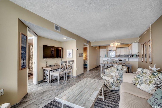 9400 Shore Dr Unit 617, Myrtle Beach, SC 29572 - living area with light wood-style flooring, a textured ceiling, and a chandelier