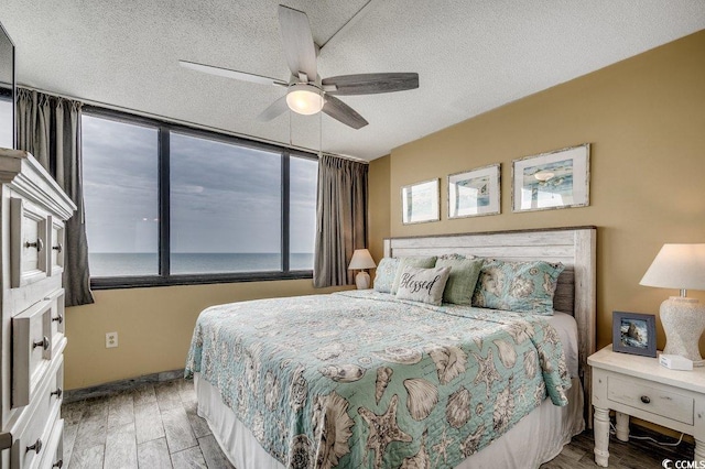 9400 Shore Dr Unit 617, Myrtle Beach, SC 29572 - bedroom with light wood-style floors, a ceiling fan, and a textured ceiling