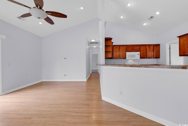 1636 Stuart Square Cir, Myrtle Beach, SC 29577 - kitchen with white microwave, ceiling fan, open shelves, light wood-style floors, and high vaulted ceiling