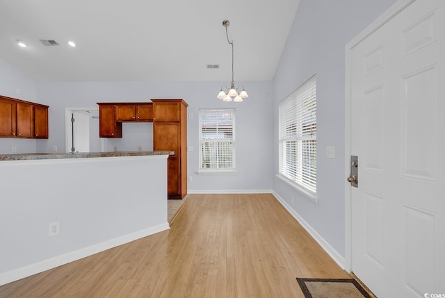 1636 Stuart Square Cir, Myrtle Beach, SC 29577 - kitchen with light wood-style flooring, a chandelier, hanging light fixtures, vaulted ceiling, and brown cabinetry