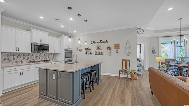598 Cascade Loop, Little River, SC 29566 - kitchen with appliances with stainless steel finishes, light wood finished floors, ornamental molding, decorative backsplash, and light countertops