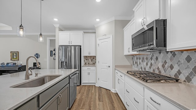 598 Cascade Loop, Little River, SC 29566 - kitchen with appliances with stainless steel finishes, white cabinetry, crown molding, pendant lighting, and light stone counters