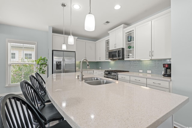 540 Chanted Dr, Murrells Inlet, SC 29576 - kitchen with appliances with stainless steel finishes, decorative backsplash, an island with sink, white cabinets, and a kitchen bar