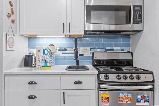 2001 S Ocean Blvd Unit 1408, Myrtle Beach, SC 29577 - kitchen featuring stainless steel appliances, white cabinetry, tasteful backsplash, and light stone counters
