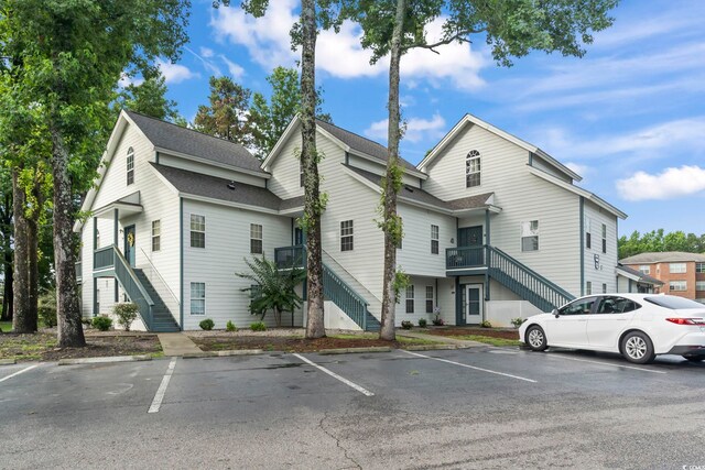 4344 Spa Dr Unit 605, Little River, SC 29566 - view of side of property with stairs, uncovered parking, and a shingled roof