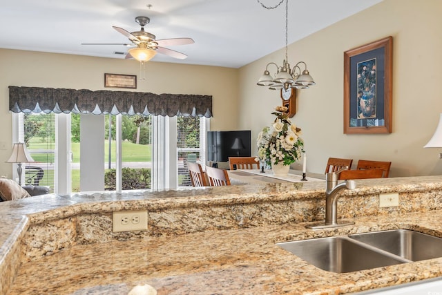 1009 World Tour Blvd Unit 105, Myrtle Beach, SC 29579 - kitchen featuring light stone countertops, a ceiling fan, hanging light fixtures, and a chandelier