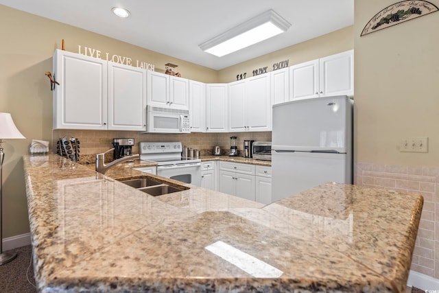 1009 World Tour Blvd Unit 105, Myrtle Beach, SC 29579 - kitchen with white appliances, light stone countertops, white cabinets, a peninsula, and recessed lighting