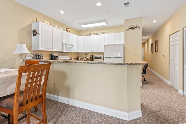 1009 World Tour Blvd Unit 105, Myrtle Beach, SC 29579 - kitchen featuring white microwave, fridge, light colored carpet, a peninsula, and light stone countertops