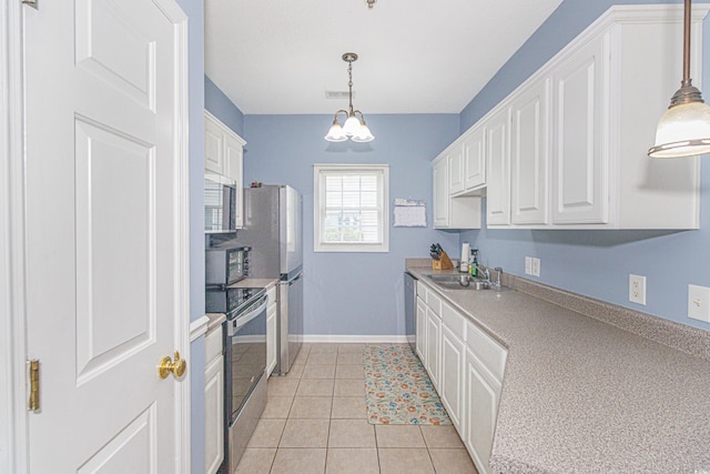2060 Cross Gate Blvd Unit 102, Surfside Beach, SC 29575 - kitchen with stainless steel appliances, white cabinets, a chandelier, light countertops, and pendant lighting