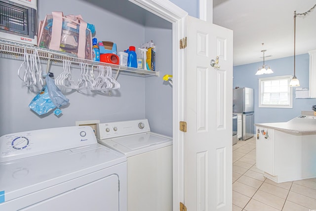 2060 Cross Gate Blvd Unit 102, Surfside Beach, SC 29575 - laundry area featuring washer and clothes dryer, light tile patterned floors, and a chandelier