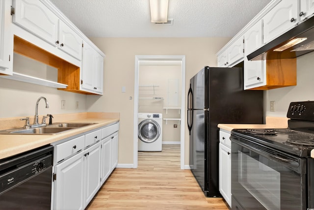 131 Pine Lake Cir, Ocean Isle Beach, NC 28469 - kitchen with black appliances, washer / clothes dryer, ventilation hood, white cabinets, and a textured ceiling