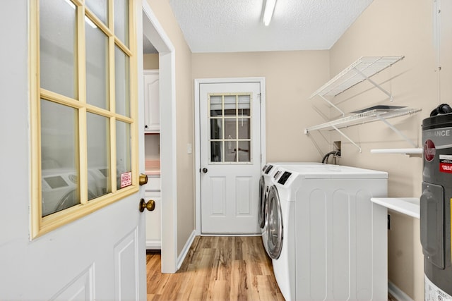131 Pine Lake Cir, Ocean Isle Beach, NC 28469 - laundry room with washer and clothes dryer, light wood-type flooring, a textured ceiling, and water heater