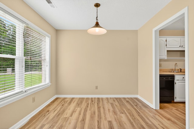 131 Pine Lake Cir, Ocean Isle Beach, NC 28469 - unfurnished dining area with plenty of natural light, light wood-style floors, wet bar, and a textured ceiling