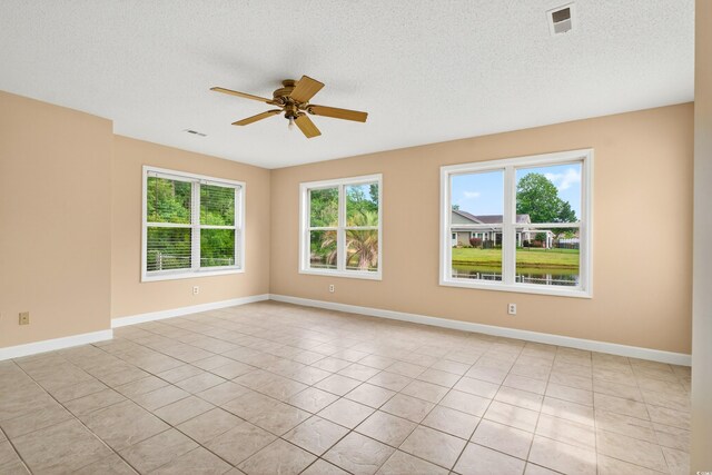 131 Pine Lake Cir, Ocean Isle Beach, NC 28469 - empty room with healthy amount of natural light, a ceiling fan, light tile patterned floors, and a textured ceiling