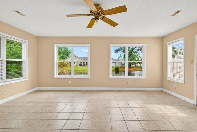 131 Pine Lake Cir, Ocean Isle Beach, NC 28469 - empty room featuring a textured ceiling, light tile patterned floors, and ceiling fan