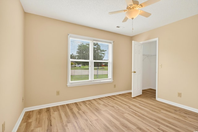 131 Pine Lake Cir, Ocean Isle Beach, NC 28469 - unfurnished bedroom featuring light wood-type flooring, a ceiling fan, a closet, and a spacious closet