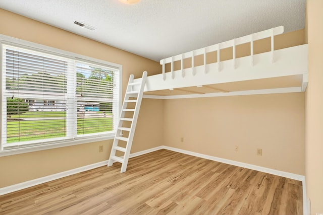 131 Pine Lake Cir, Ocean Isle Beach, NC 28469 - unfurnished bedroom featuring wood finished floors and a textured ceiling