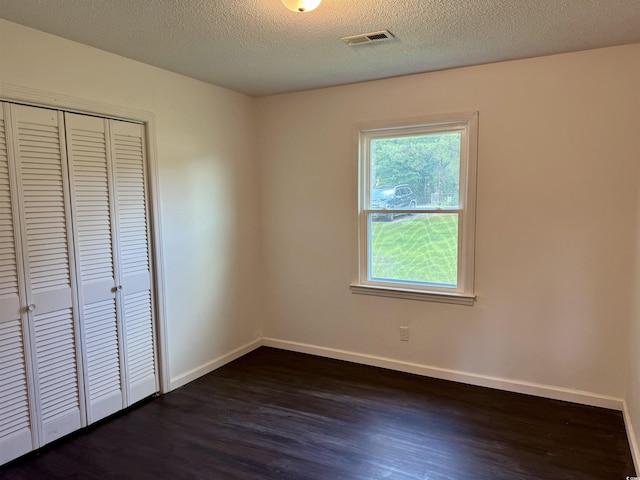 109 S Maple Ave, Andrews, SC 29510 - unfurnished bedroom with dark wood-type flooring, a closet, and a textured ceiling