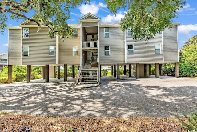 140 S Cove Pl Unit 6C, Pawleys Island, SC 29585 - view of building exterior with a carport, stairway, and driveway