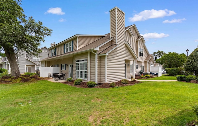 503 20th Ave N Unit 29-C, North Myrtle Beach, SC 29582 - back of property with a chimney, a lawn, a patio area, and roof with shingles
