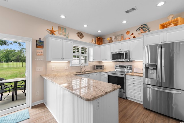 503 20th Ave N Unit 29-C, North Myrtle Beach, SC 29582 - kitchen with stainless steel appliances, a peninsula, white cabinets, healthy amount of natural light, and recessed lighting
