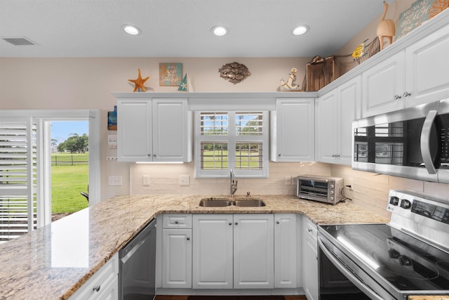 503 20th Ave N Unit 29-C, North Myrtle Beach, SC 29582 - kitchen featuring appliances with stainless steel finishes, white cabinets, decorative backsplash, recessed lighting, and light stone countertops