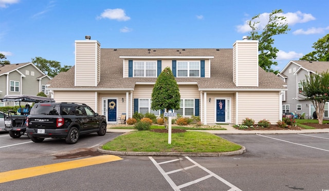 503 20th Ave N Unit 29-C, North Myrtle Beach, SC 29582 - townhome / multi-family property featuring a chimney, uncovered parking, a shingled roof, and a front lawn