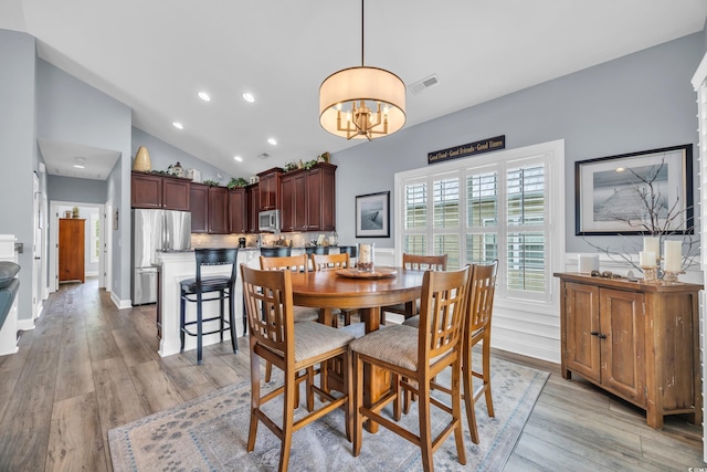 1413 Cottage Cove Cir N, Myrtle Beach, SC 29582 - dining room featuring light wood-style floors, a chandelier, a wainscoted wall, recessed lighting, and high vaulted ceiling