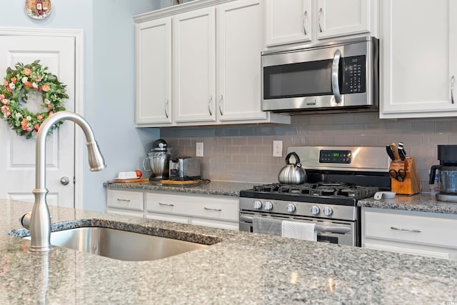 308 Firenze Loop, Myrtle Beach, SC 29579 - kitchen featuring appliances with stainless steel finishes, decorative backsplash, white cabinets, and light stone counters