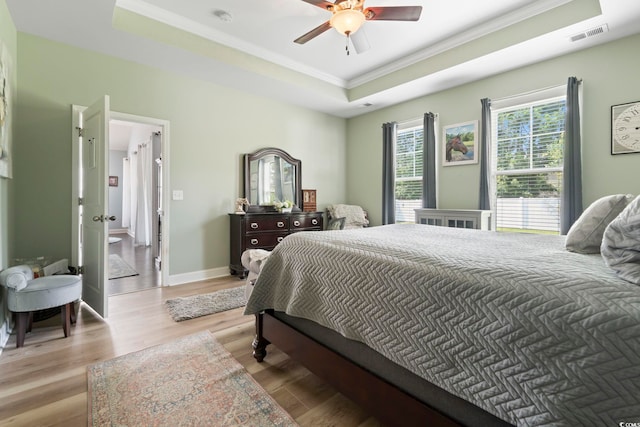 308 Firenze Loop, Myrtle Beach, SC 29579 - bedroom featuring crown molding, a raised ceiling, light wood-style flooring, and a ceiling fan