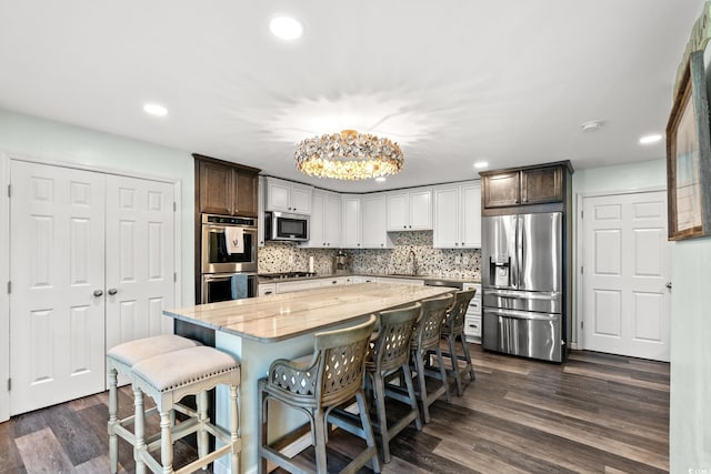 4806 S Ocean Blvd, Surfside Beach, SC 29575 - kitchen with appliances with stainless steel finishes, recessed lighting, light stone counters, tasteful backsplash, and dark wood-style floors