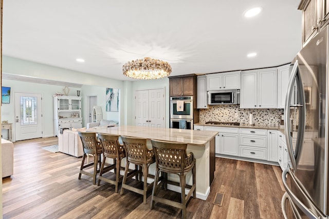 4806 S Ocean Blvd, Surfside Beach, SC 29575 - kitchen with stainless steel appliances, a chandelier, a breakfast bar area, dark wood-style flooring, and recessed lighting