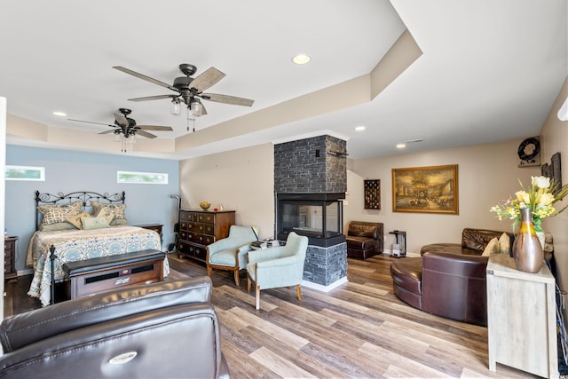 4806 S Ocean Blvd, Surfside Beach, SC 29575 - bedroom with a raised ceiling, wood finished floors, a fireplace, recessed lighting, and ceiling fan