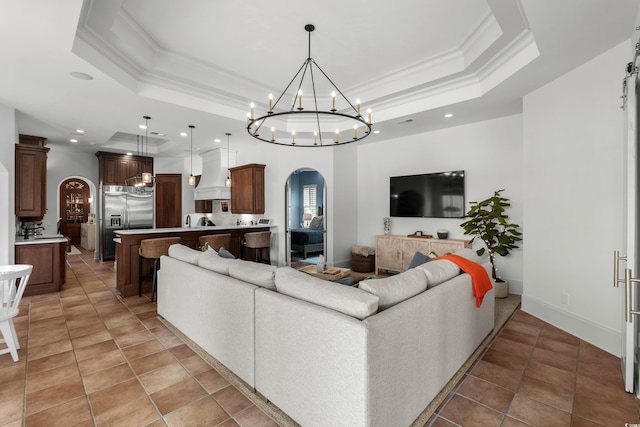 9737 Catalonia Ct, Myrtle Beach, SC 29579 - living room featuring arched walkways, a raised ceiling, a chandelier, crown molding, and recessed lighting